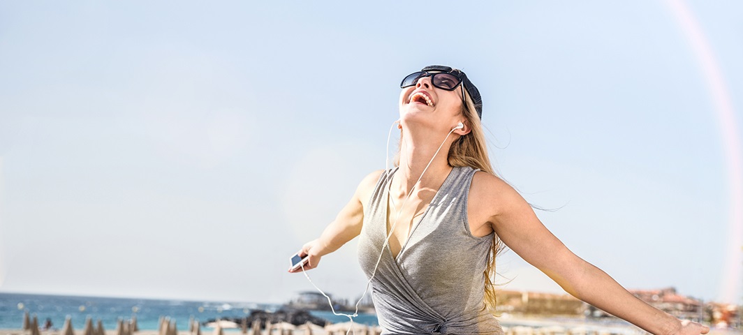 happy woman at beach with headphones